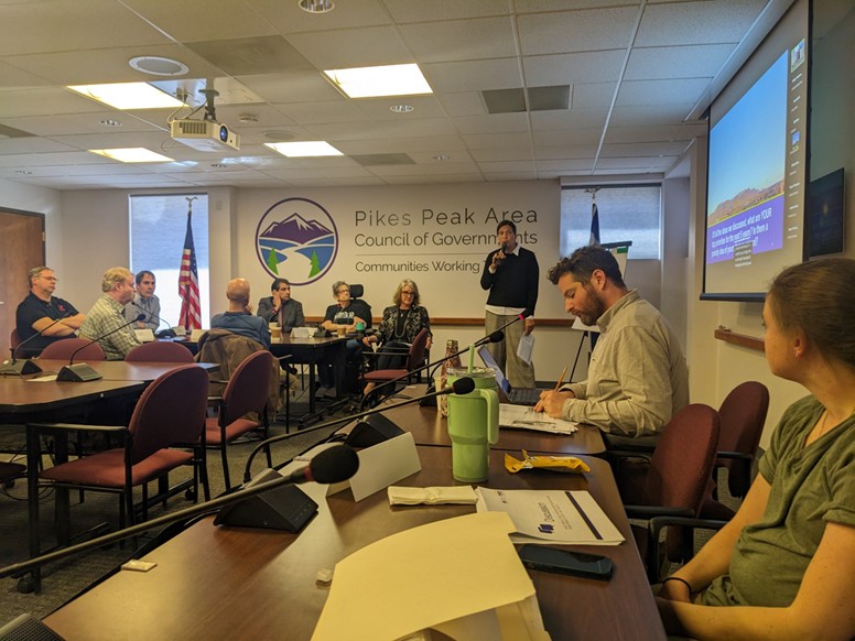 A group of people sitting around tables during transit plan stakeholder meetings.