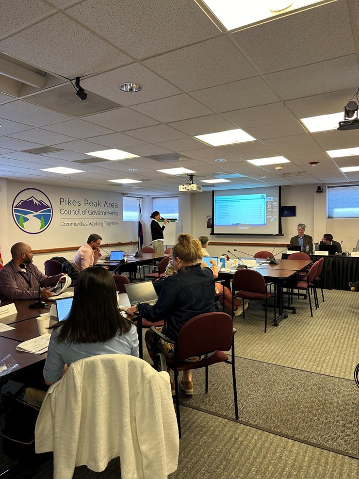 A group of people sitting around tables during transit plan stakeholder meetings.