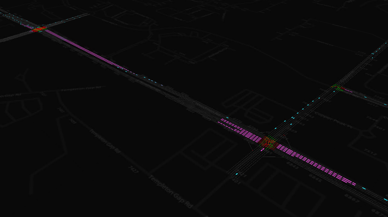 A screen capture of SBA traffic animation along Woodmen Rd in Colorado Springs, with pink vehicles queuing at signalized intersections during the morning commute while the light blue vehicles are in motion along the network
